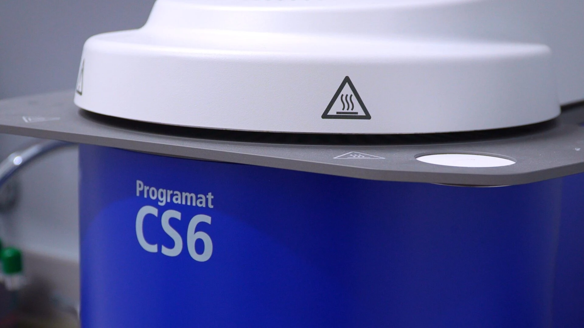 Close-up view of the Programat CS6 dental combination furnace featuring its signature blue exterior and safety warning labels.